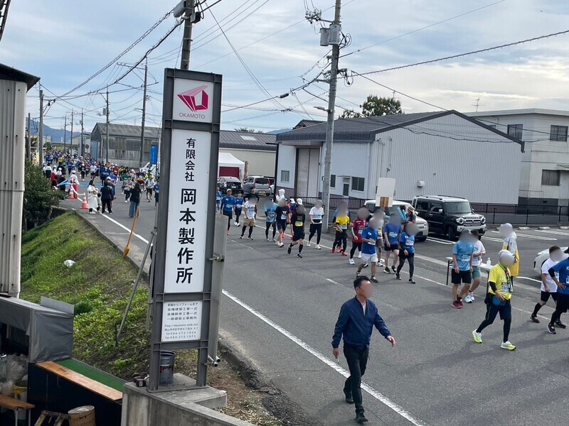 岡本製作所の看板とランナーの皆さんの様子